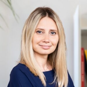 A woman with blonde hair wearing a blue shirt.