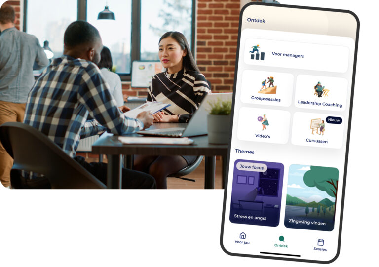 Een man en vrouw voeren een gesprek aan een bureau in een modern kantoor. Vooraan toont een smartphonescherm een Nederlandse app met opties voor managers, groepssessies, coaching, video's en cursussen.