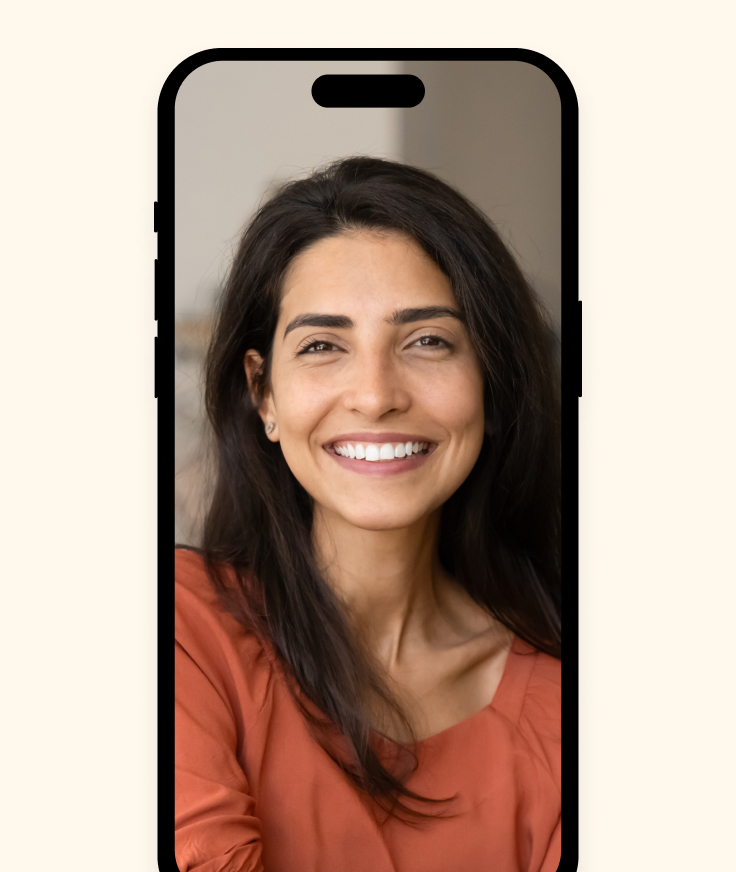 A woman with long dark hair and a coral top smiles at the camera, framed within the outline of a smartphone on a light background—capturing how organizations attract and retain talent in today’s digital world.