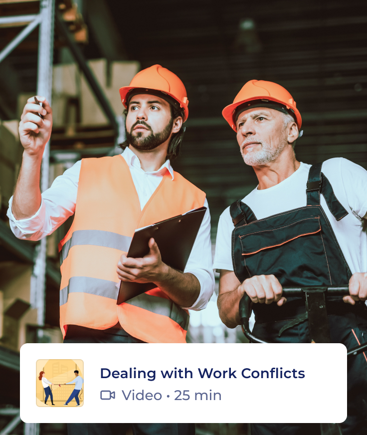 Two men in safety vests and orange hard hats stand in a construction warehouse. One points ahead while the other listens, holding a tool. A video title overlay reads “Dealing with Work Conflicts,” with a 25-minute duration.